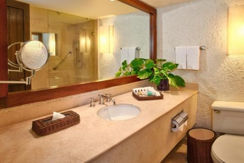 a bathroom with a sink and a mirror and a toilet at Las Brisas Ixtapa in Ixtapa