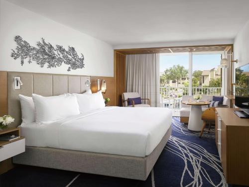 Habitación de hotel con cama grande y escritorio. en Hilton Fort Lauderdale Marina en Fort Lauderdale