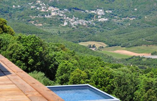 a swimming pool on a deck with a view of a mountain at Le Tomino in Macinaggio