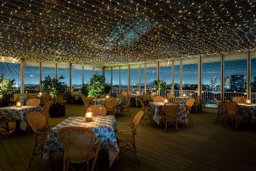 um restaurante com mesas, cadeiras e luzes em The Beverly Hilton em Los Angeles