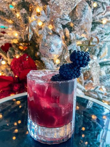 a drink with blackberries in a glass on a table at The Beverly Hilton in Los Angeles