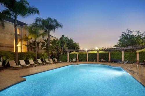 a large swimming pool with lounge chairs at Hilton Garden Inn LAX - El Segundo in El Segundo