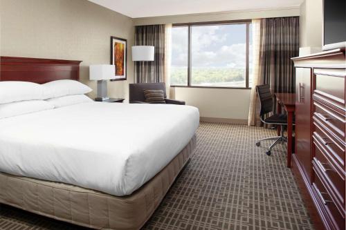 a hotel room with a large bed and a desk at DoubleTree by Hilton Kansas City - Overland Park in Overland Park