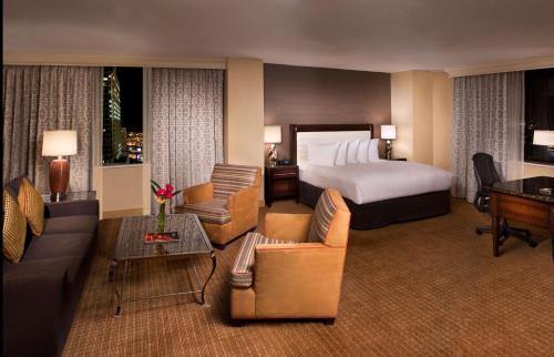 a hotel room with a bed and a living room at Hilton Minneapolis in Minneapolis