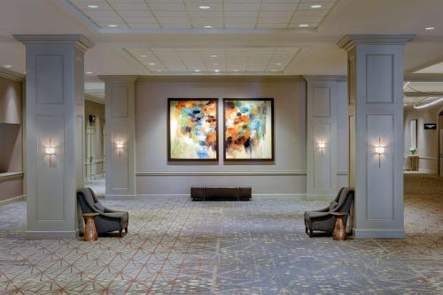 a lobby with two chairs and a painting on the wall at Hilton Minneapolis in Minneapolis
