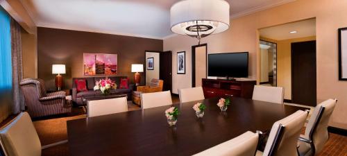 a dining room with a table and a living room at Hilton Minneapolis in Minneapolis