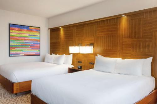 two beds in a hotel room with white pillows at Hilton New York Times Square in New York