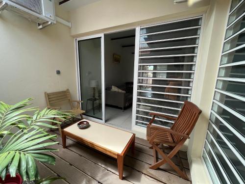 a patio with two chairs and a table and a window at Le 5 Nord in Cayenne