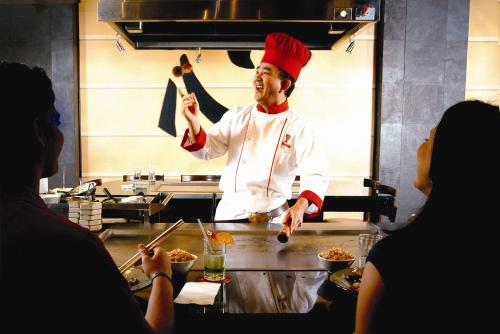 a chef standing in a kitchen preparing food at Hilton Orlando Lake Buena Vista - Disney Springs™ Area in Orlando