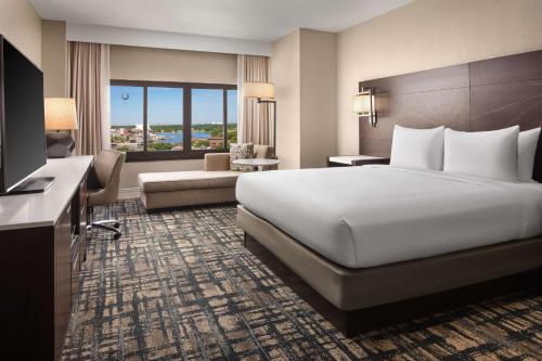a hotel room with a large bed and a television at Hilton Orlando Lake Buena Vista - Disney Springs™ Area in Orlando