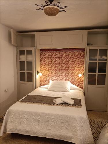 a bedroom with a large bed with two towels on it at Casa James in Vejer de la Frontera