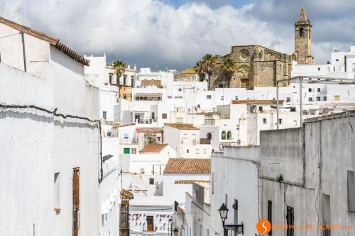 a group of white buildings with a clock tower at Casa James in Vejer de la Frontera