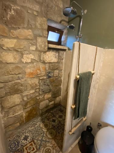 卡拉布倫的住宿－Toscany house in Tepeboz, Izmir，一间石墙和淋浴的浴室