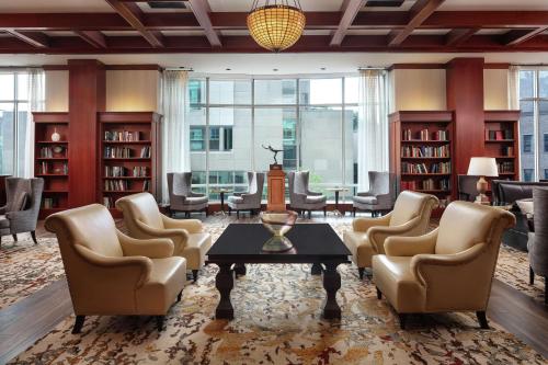 a library with chairs and a table and bookshelves at The Inn at Penn, A Hilton Hotel in Philadelphia