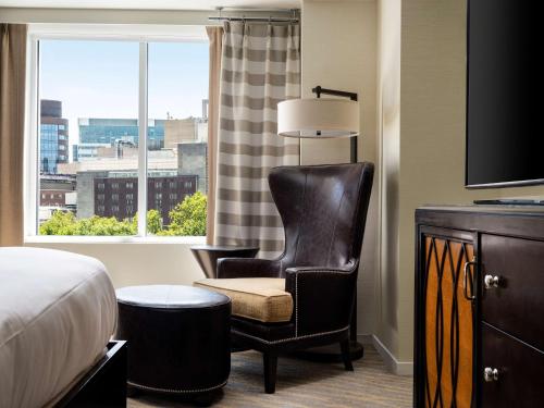 a hotel room with a chair and a window at The Inn at Penn, A Hilton Hotel in Philadelphia