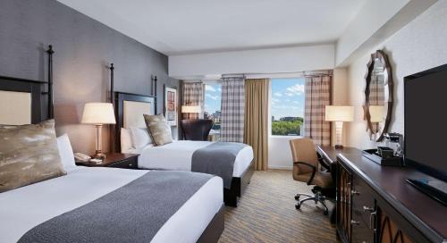 a hotel room with two beds and a desk at The Inn at Penn, A Hilton Hotel in Philadelphia