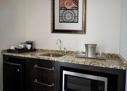 a kitchen with a sink and a microwave at The Inn at Penn, A Hilton Hotel in Philadelphia