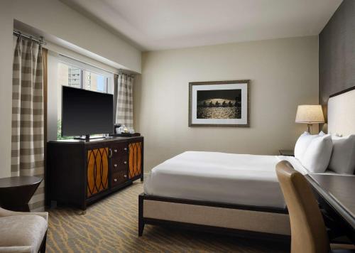 a hotel room with a bed and a flat screen tv at The Inn at Penn, A Hilton Hotel in Philadelphia