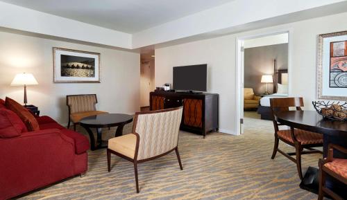 a hotel room with a red couch and a living room at The Inn at Penn, A Hilton Hotel in Philadelphia