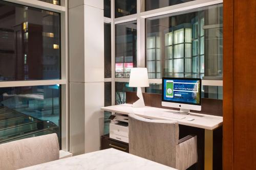 a computer sitting on a desk in a room with windows at The Inn at Penn, A Hilton Hotel in Philadelphia