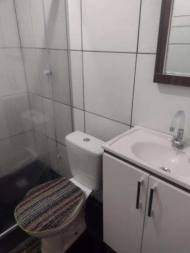 a white bathroom with a toilet and a sink at Gramado Família in Gramado