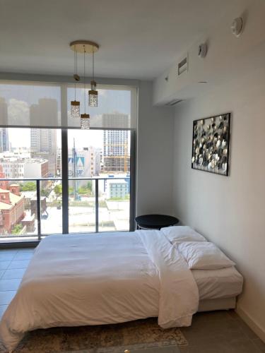 Brand NEW modern 1 bedroom unit Downtown في ميامي: غرفة نوم بسرير كبير ونافذة كبيرة