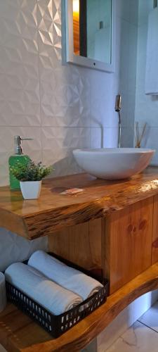 La salle de bains est pourvue d'un comptoir en bois et de deux lavabos. dans l'établissement Chalés Sossego da Serra, à Urubici