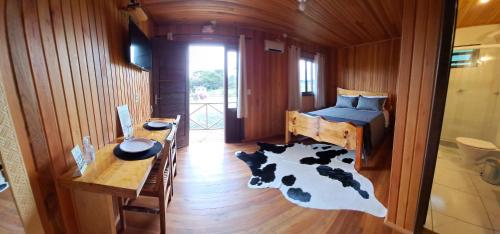 a bedroom with a bed and a cow rug at Chalés Sossego da Serra in Urubici
