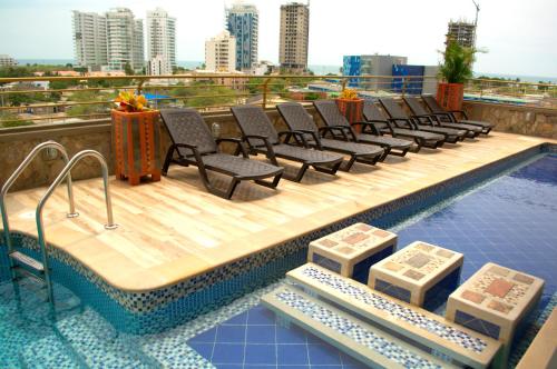 a row of chairs sitting on top of a swimming pool at L / Apto 95m2 en Terrazas Tayrona 6 a 8 pax in Gaira