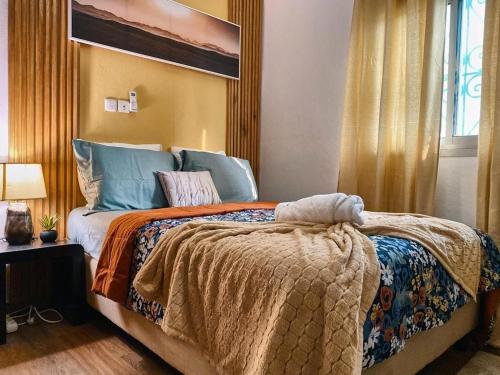 - une chambre avec un grand lit et une fenêtre dans l'établissement Roswell Luxury Properties Yaoundé - Quartier FOUDA, à Yaoundé