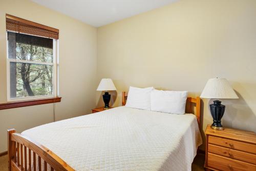 a bedroom with a bed with two lamps and a window at Vista Azul in Oceanside
