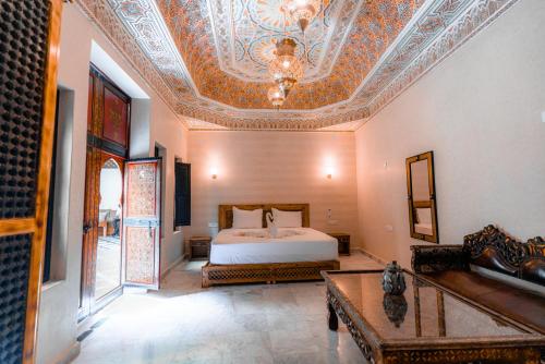 1 dormitorio con cama y techo artesonado en Riad Deluxe, en Marrakech