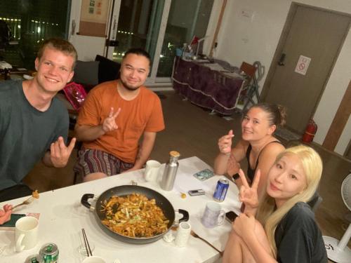 a group of people sitting around a table with food at Guesthouse Comfort Place in Buan