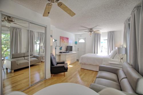 a large white bedroom with a bed and a mirror at Gulside Resort. Unit 8 in St. Pete Beach