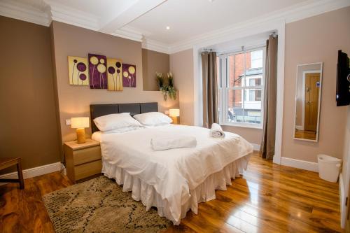 a bedroom with a large white bed and a window at Tavmar Rooms in Lincoln