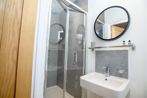 a bathroom with a sink and a shower with a mirror at Tavmar Accommodation in Lincoln