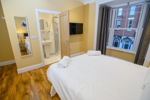a bedroom with a large white bed and a window at Tavmar Accommodation in Lincoln