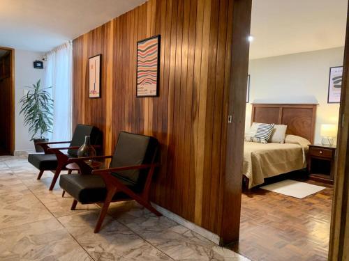 a bedroom with a bed and a table and chairs at Casa Tigris in Mexico City