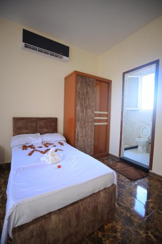a bedroom with a large white bed and a bathroom at El Khalil Pyramids View Inn in Cairo