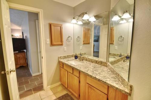 La salle de bains est pourvue d'un lavabo et d'un grand miroir. dans l'établissement Centrally Located Parking Included, à Houston