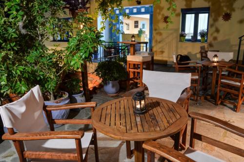 una mesa y sillas en una habitación con plantas en Hotel Dina - Ξενοδοχείο Ντινα, en Plati