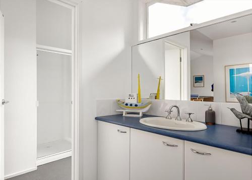 a bathroom with a sink and a mirror at Pool Haven on Leah in Rye