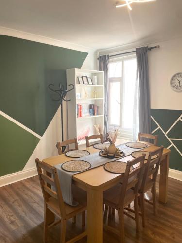 a dining room with a wooden table and chairs at Home Sweet Home in RG1 with FREE Parking in Reading