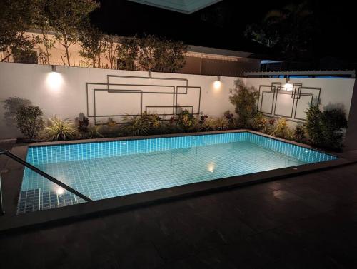 a swimming pool in a backyard at night at The Oasis Villa Just 150m to the Beach in Koh Samui