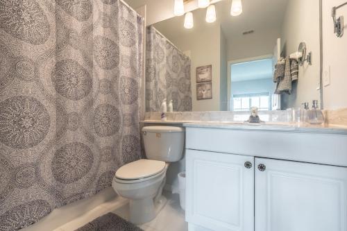 a bathroom with a toilet and a sink and a mirror at Spacious 2BR Lely Resort Condo with Lake View steps to Pool Hot Tub Gym in Naples