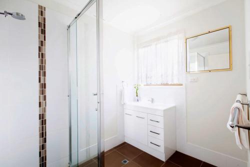 biała łazienka z umywalką i prysznicem w obiekcie Bunya Mountains Tavern 