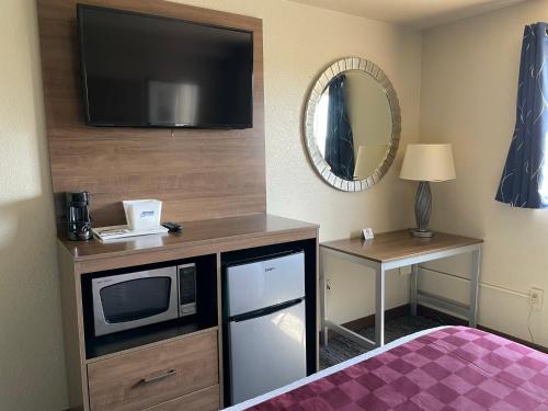 a hotel room with a tv and a microwave at Americas Best Value Inn Lynnwood in Lynnwood