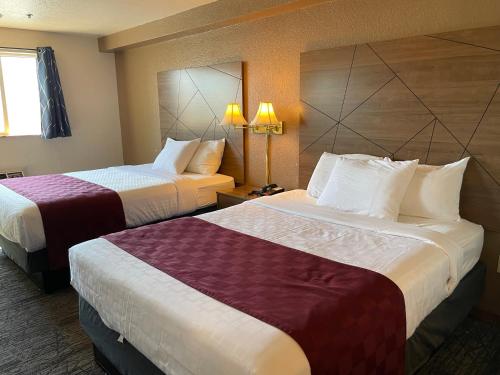 a hotel room with two beds and two lamps at Americas Best Value Inn Lynnwood in Lynnwood