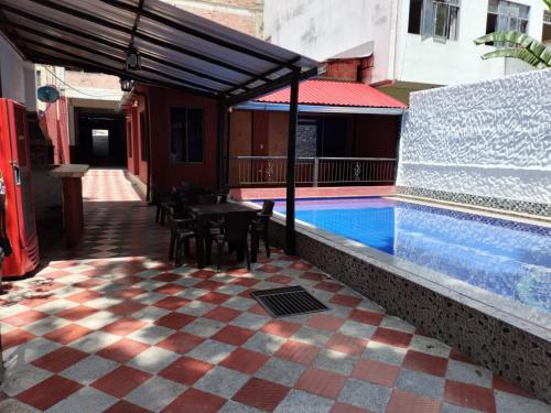 un patio con una mesa y una piscina en Hotel la Isabela By Marbar, en Villeta