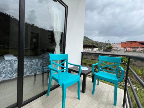 two blue chairs on a balcony with a bed at Brand new Holiday Villa - 3 bedroom 4 bathroom in Baños